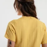 Blusa verde de manga corta con escote en V profundo y textura acanalada o plisada verticalmente. Corte holgado.