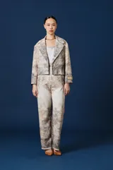 Saco de mujer con solapas clásicas y corte recto, confeccionado en tejido con estampado de paisaje natural en tonos tierra. Presenta un parche con logo en la manga y diseño de estructura relajada.