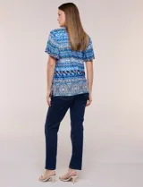 Blusa estampada en tonos azules con escote en V y cuello con frunces. Tiene mangas cortas amplias estilo mariposa y corte recto a la cadera.