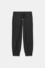 Pantalón tipo jogger de tiro medio, con cintura elástica ajustable mediante cordones y bolsillos delanteros. Presenta un corte holgado con terminación en puños elásticos en los tobillos.