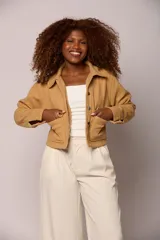 Chaqueta corta de paño en color tostado, con cuello camisero, cierre frontal con botones metálicos y dos bolsillos frontales tipo parche.