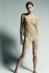 Top de tirantes finos con escote recto, confeccionado en tejido de encaje semitransparente con hilo metalizado dorado.