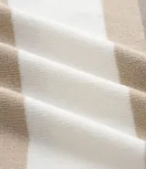 Suéter de punto con cuello redondo y manga larga, diseñado con un patrón de bloques de color en tonos beige, blanco y gris. Presenta un corte regular que se ajusta de forma anatómica al cuerpo.