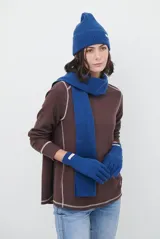 Remera de manga larga en color beige, confeccionada en tejido de punto con costuras a la vista en contraste. Presenta un corte holgado, cuello redondo y un pequeño bordado distintivo en la parte inferior.