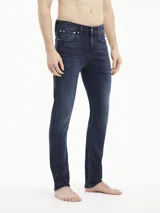 Jeans skinny de denim azul oscuro, tiro bajo, con cinco bolsillos y cierre de cremallera. Confeccionado con algodón reciclado y elastano.