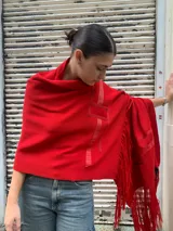 Chaleco tipo pashmina rojo de tejido de punto con flecos.