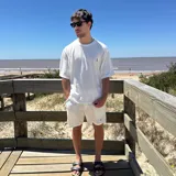 Remera negra tejida con cuello redondo y manga corta, con logo bordado en el pecho.