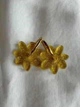 Aros de argolla metálica con dije colgante en forma de flor de acrílico color rosado.