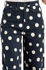 Jean de corte baggy y tiro alto, confeccionado en denim azul marino con estampado de lunares blancos, estilo barrel.