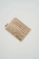 Tarjetero minimalista de color dorado metálico, con múltiples ranuras para tarjetas.