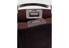 Bolso tipo tote color marrón oscuro, confeccionado en poliuretano con acabado brillante y diseño estructurado de gran tamaño.