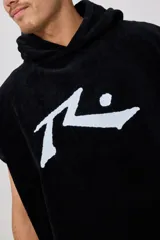 Poncho de toalla con capucha en color azul marino, confeccionado en 100% algodón. Presenta un bordado blanco del logo de Rusty en el pecho.