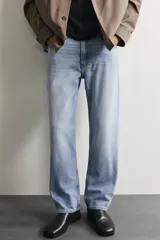 Pantalón de jean corte slim fit con efecto lavado, tiro medio, cinco bolsillos y cierre frontal con cremallera y botón.