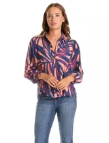 Camisa de gasa con estampado de hojas en tonos azul y coral, con cuello camisero, cierre frontal de botones y mangas tres cuartos con puños fruncidos.