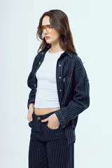Camisa de denim de corte oversize, color celeste, con bolsillos frontales con solapa y botones metálicos.