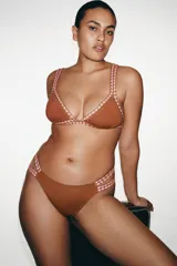 Top bikini triangular marrón con tirantes múltiples y detalles de crochet en contraste de color rosado y marrón en los bordes y las tiras.