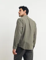 Camisa de cuello mao y manga larga, confeccionada en una mezcla de lino y algodón. Presenta un diseño de corte recto con botones en tono natural y un bolsillo pequeño en el pecho.