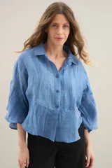 Camisa de silueta amplia y fluida color celeste, con cuello camisero clásico y mangas cortas amplias.