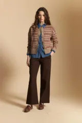 Cardigan corto de tejido jacquard con diseño geométrico en tonos beige y crema, con cierre frontal de botones y cuello redondo.