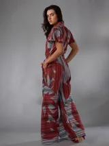Mono de lino mezcla con estampado vegetal en tonos rojos, grises y blancos, de manga corta, escote en V y piernas amplias con cinto incorporado para ajustar la cintura.