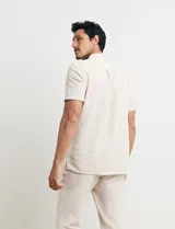 Camisa de manga corta con cuello mao y cierre frontal parcial con botones de coco. Confeccionada en una mezcla de lino y algodón.