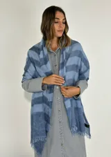Pashmina rectangular con diseño a rayas horizontales en tonos de azul y flecos en los extremos.