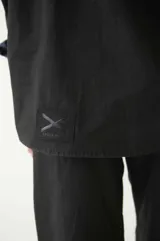 Camisa negra de manga larga y corte semi holgado, con canesú en la espalda, abotonada en el frente y con cuello camisero.