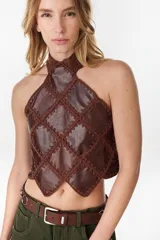 Top halter de cuero marrón con inserciones unidas mediante tejido de punto artesanal formando un patrón romboidal, con cuello alto y dobladillo en punta.