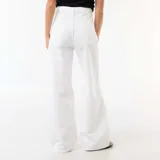 Pantalón wide leg de denim blanco, tiro bajo, con detalles rotos en las rodillas y diseño amplio.