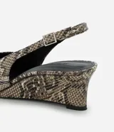 Zapato tipo slingback con estampado de piel de serpiente, puntera fina y taco anabela de 5 cm. Cuenta con tira ajustable en el talón con hebilla metálica.