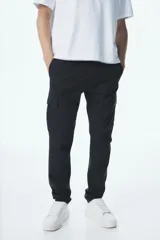 Pantalón cargo negro de corte slim fit, con cintura elástica ajustable con cordón, bolsillos laterales, bolsillos cargo con solapa y botones a presión ocultos, y pinzas en las rodillas.