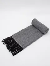Bufanda tejida con diseño de espiga en tonos grises y negros, con terminación de flecos negros en los extremos.