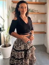 Top corto negro de manga tres cuartos con escote en V y aberturas en los hombros. Presenta tiras cruzadas en la cintura.