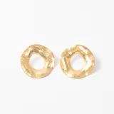 Aros tipo argolla de diseño circular con textura irregular y acabado en tono dorado.