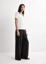 Camiseta blanca de algodón con cuello redondo, mangas cortas y detalle de bordado floral en el frente.