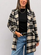 Chaqueta larga de corte recto con estampado de cuadros en tonos marrones y beige. Presenta solapas clásicas, cierre frontal con un botón, bolsillos laterales y forro interior.