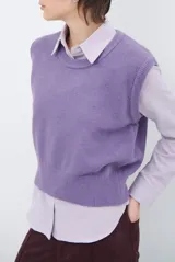 Chaleco de punto sin mangas, color azul, con cuello redondo y diseño de calce holgado.