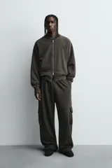 Chaqueta tipo bomber de corte relajado, confeccionada en tejido de mezcla de algodón con interior perchado. Presenta cuello subido, cierre frontal con cremallera, bolsillos de vivo en la cadera y acabados en rib en puños y bajo. Posee un acabado con efecto lavado.