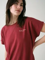 Camisón blanco de algodón, de corte holgado, manga corta y largo por encima de las rodillas. Presenta una pequeña estampa localizada en el pecho y aberturas en los laterales.