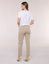 Pantalón color beige de corte entallado y largo cropped, confeccionado en tejido de punto con elasticidad técnica. Cuenta con pretina ancha y plana, bolsillos simulados al frente y bolsillos tipo ojal en la parte posterior.