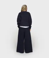 Sweater corto de punto color azul marino, de corte holgado y cuello redondo. Confeccionado en una mezcla de alpaca y lana cepillada con acabado suave y ribetes elásticos.