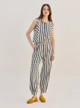 Pantalón tipo bombacha de campo color beige, de corte holgado con pinzas en la cintura y puños ajustados en los tobillos. Presenta costuras a contratono y bolsillos laterales.