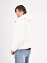 Campera puffer blanca con cuello alto, cierre frontal y diseño acolchado horizontal.