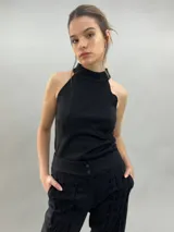 Pantalón tipo babucha confeccionado en lana de oveja, color visón. Presenta un diseño de tiro alto con textura vertical plisada a lo largo de las piernas, cintura con cierre de doble broche y puños elásticos en los tobillos.