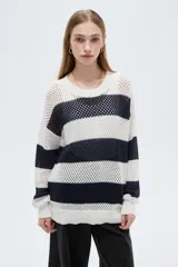 Sweater de tejido de punto calado con diseño a rayas horizontales en color blanco y azul marino, cuello redondo y mangas largas.