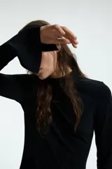 Vestido mini de manga larga confeccionado en punto interlock pesado. Presenta cuello mao, bolsillos delanteros decorativos con solapa y puños levemente acampanados con abertura. Incluye cierre oculto en la parte posterior.