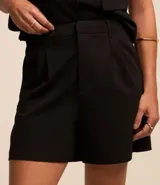 Short de vestir color fucsia, de tiro alto, con pliegues delanteros, bolsillos laterales y trabillas para cinturón.