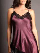 Top asimétrico de raso color bordó con escote en V y detalles de encaje negro en el escote y el dobladillo.