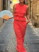 Pantalón largo de tiro alto con estampado a cuadros vichy en tonos rojo y blanco, de corte recto y holgado.