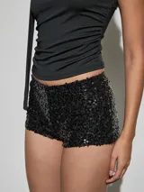 Short negro de tiro medio, completamente cubierto de lentejuelas brillantes, con calce ajustado y corte corto.